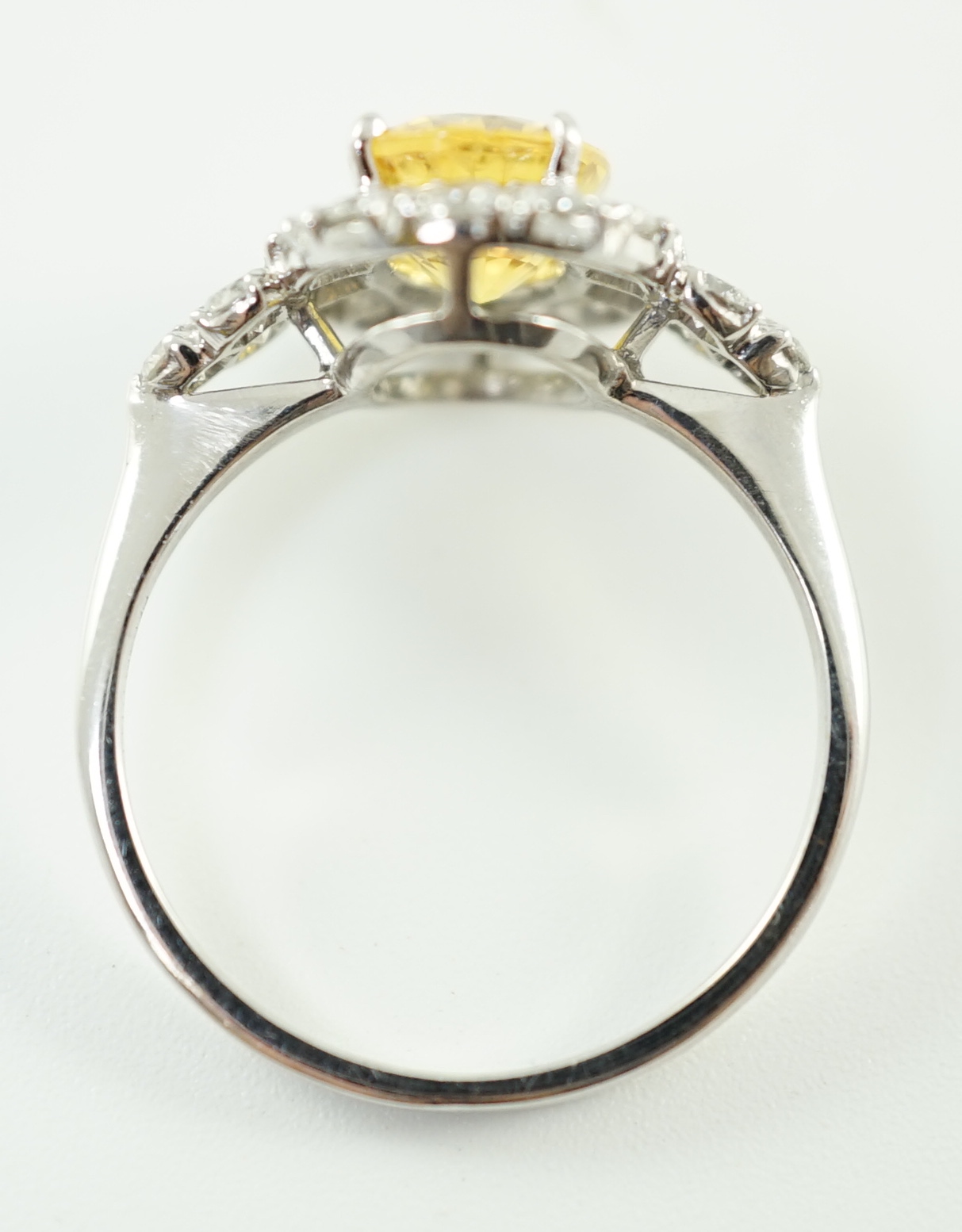 A modern 18ct white gold and single oval cut yellow sapphire set ring